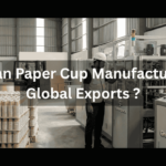 A worker operating paper cup manufacturing machinery in a Greenpack factory facility.